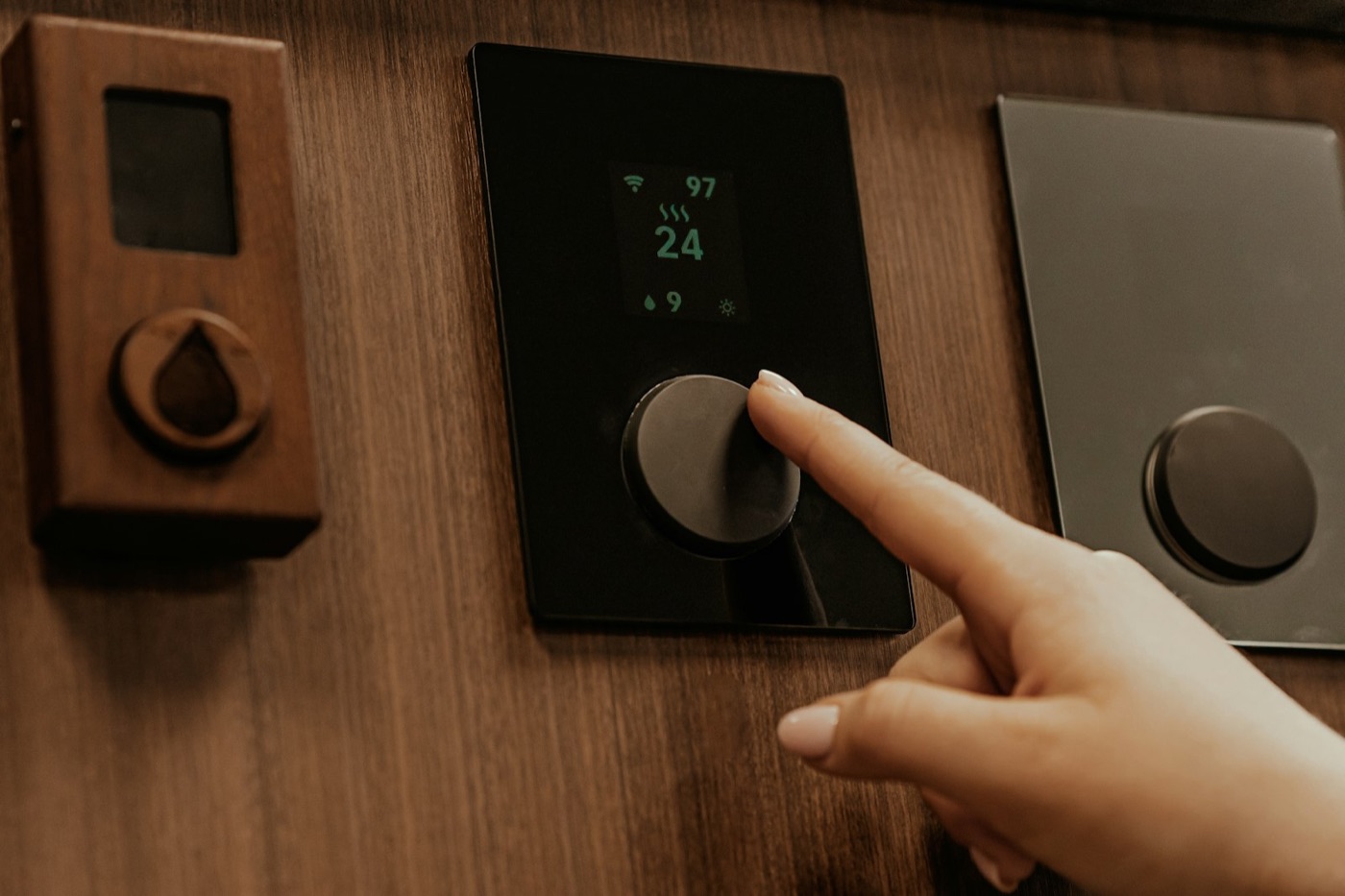 Main appuyant sur un thermostat mural